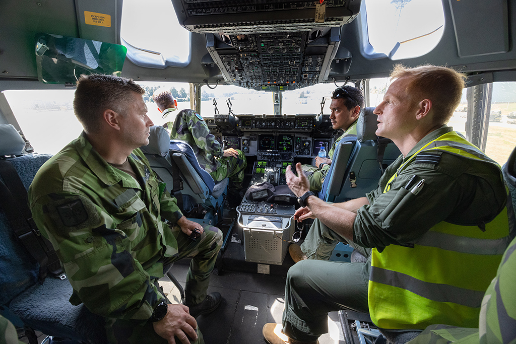 Three members of the Swedish Airforce sit in the Globemaster cockpit with an RAF counterpart who explain objects and answer their questions.